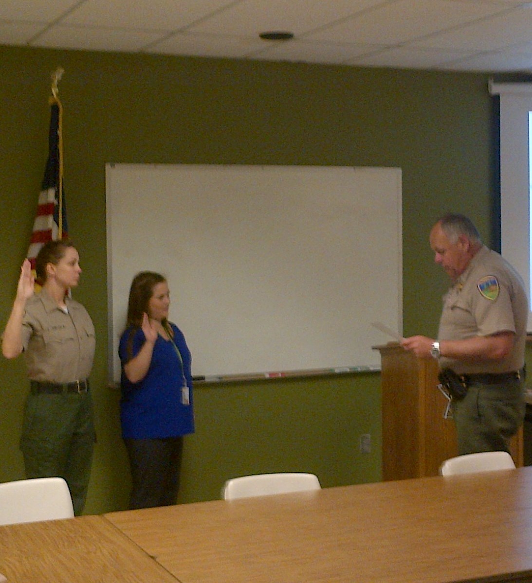 One female deputy sheriff, one woman in business casual attire, and Sheriff Mike Downey